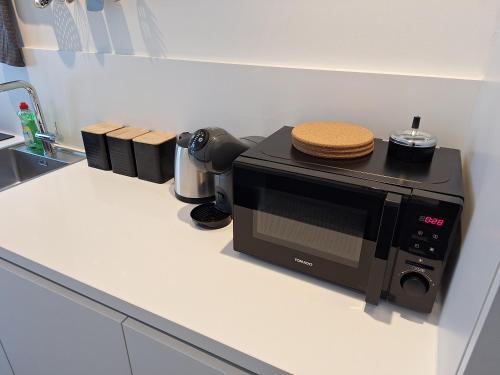 a microwave sitting on a counter in a kitchen at Huis ALNA 5 in Mechelen