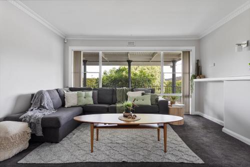 a living room with a couch and a table at Legana Lodge - A home away from home - Catering for up to 12 guests in Legana
