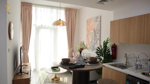 uma cozinha com uma mesa, um lavatório e uma janela em Executive 1BR apartment em Abu Dhabi