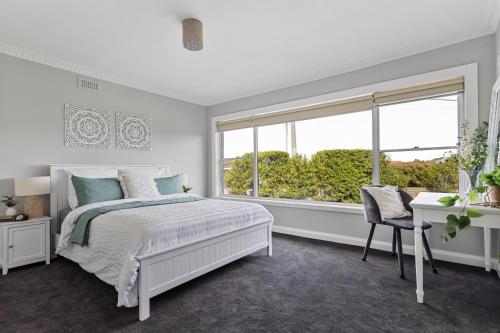 a white bedroom with a bed and a window at Legana Lodge - A home away from home - Catering for up to 12 guests in Legana