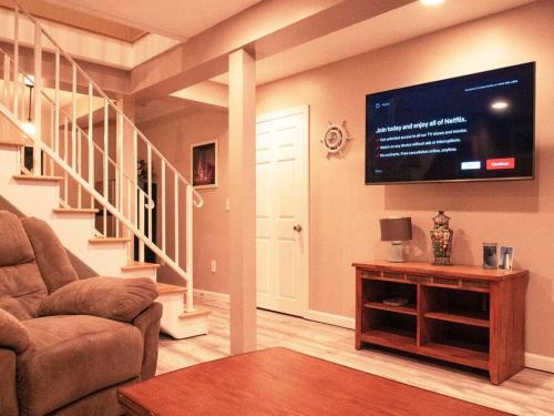 a living room with a large flat screen tv on the wall at Spacious 4BR Home near Water Park, Pond & Beaches in Bourne
