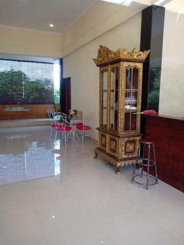 a large room with a china cabinet and chairs at Ubud Suites Batuan in Sukawati