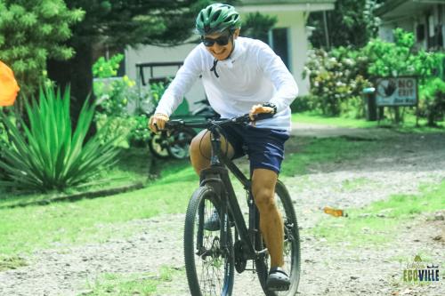 a man riding a bike in a yard at Caliraya Ecoville Recreation and Farm Resort in Cavinti
