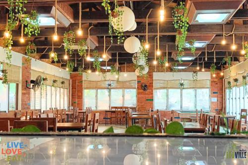 a dining room with tables and chairs and plants at Caliraya Ecoville Recreation and Farm Resort in Cavinti