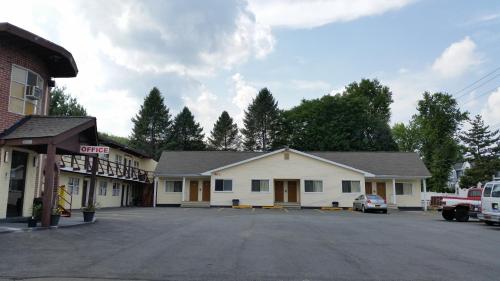a parking lot in front of a white building at Budget Motor Inn- Stony Point in Stony Point