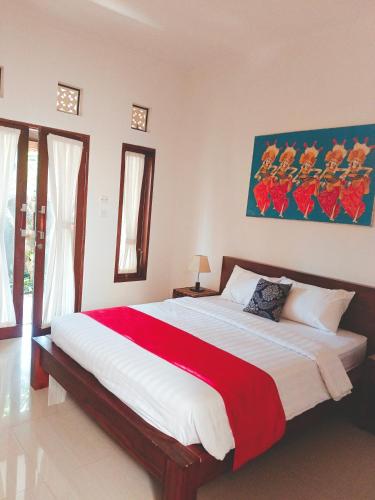 Un dormitorio con una cama grande con una manta roja. en Taman Bali Homestay, en Sanur