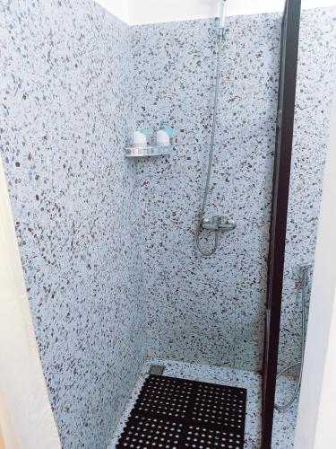y baño con ducha y rejilla negra. en Taman Bali Homestay, en Sanur