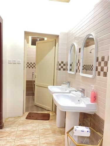 a bathroom with two sinks and a shower at شقة الشفاء فالي in Hail