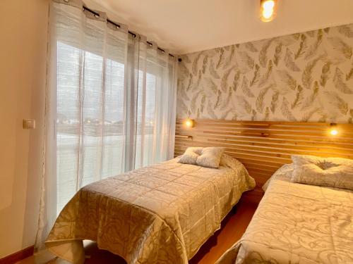 a bedroom with two beds and a window at Green&Blue in Ribeira Grande