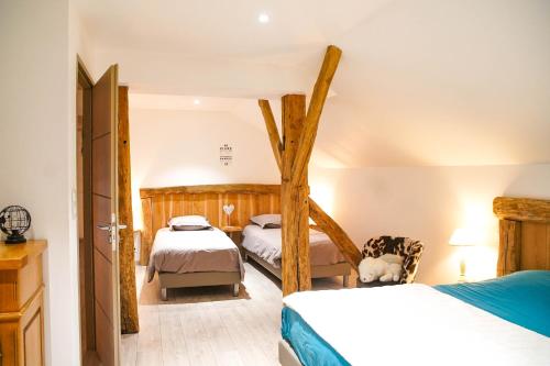 a bedroom with two beds and a tree in it at Gîte des PRARY des Mille étangs in Ternuay-Melay-et-Saint-Hilaire