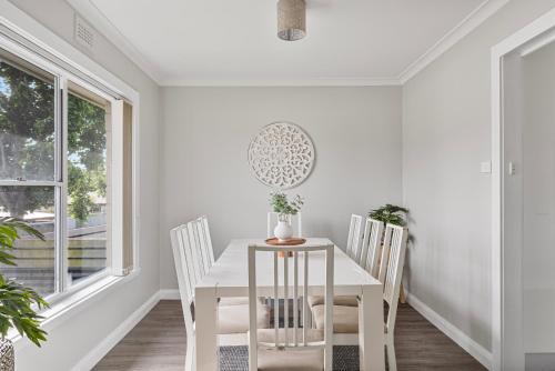 a white dining room with a white table and chairs at Legana Lodge - A home away from home - Catering for up to 12 guests in Legana