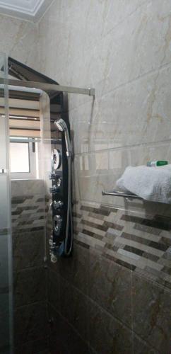a bathroom with a shower and a bed in it at FOKUZZY LODGE in Accra