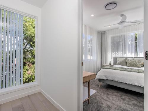 a bedroom with a bed and a large window at Luxury Mermaid Waters Holiday Home in Gold Coast