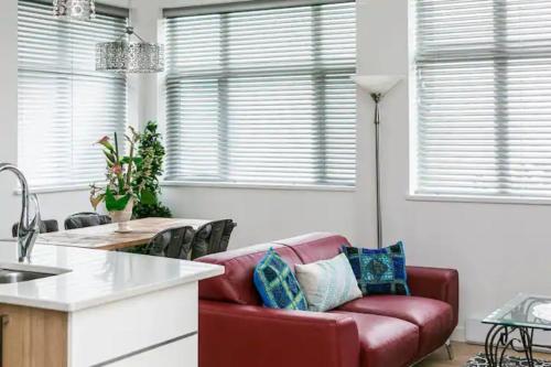 uma sala de estar com um sofá vermelho numa cozinha em Incredible Views Beautiful 2-Bedroom Suite em Victoria