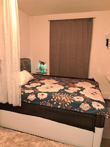 um quarto com uma cama com colcha floral em Mystay42 em Lucerna