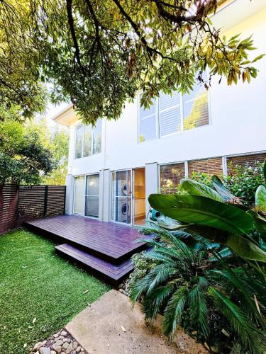 a house with a wooden deck in the yard at Luxurious Comfort with Bay Views in Frankston South