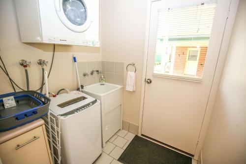 un piccolo bagno con lavatrice e asciugatrice di Silver Birches Holiday Village - Unit 7 a Bright