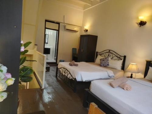 a hotel room with two beds and a hallway at Beach Street by Plush in George Town