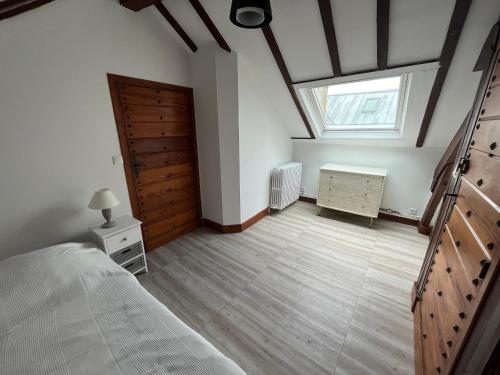 a bedroom with a bed and a wooden door at Grand studio 65m² à Saint-Esprit, Bayonne - WiFi, près gare - FR-1-239-996 in Bayonne