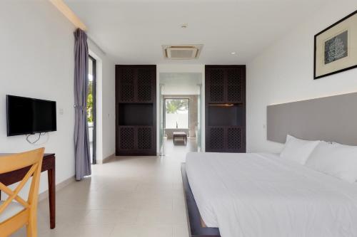 sypialnia z łóżkiem, biurkiem i telewizorem w obiekcie BIỆT THỰ 3 PHÒNG NGỦ BÊN BỜ BIỂN w mieście Ba Ria