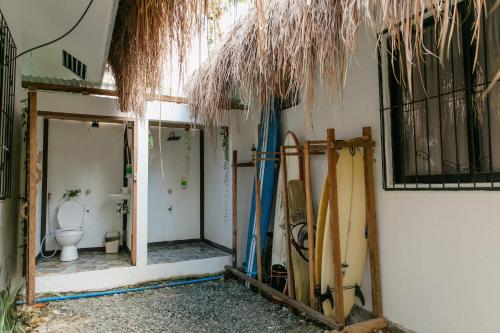 a room with surfboards and a bathroom with a toilet at Ozen Freediving Hostel in General Luna