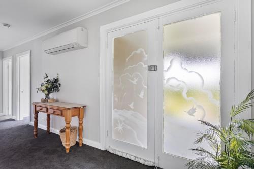 a sliding glass door with a table next to it at Legana Lodge - A home away from home - Catering for up to 12 guests in Legana
