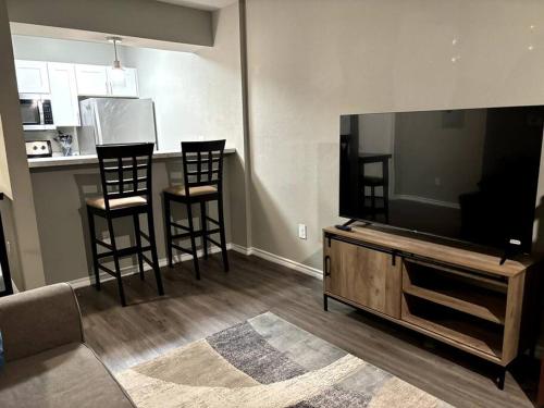 ein Wohnzimmer mit 2 Stühlen und einem Flachbild-TV in der Unterkunft Apartment in Dallas