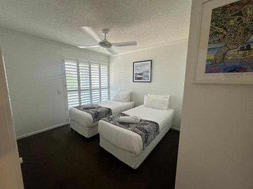 a bedroom with two beds and a couch at Kawana Waters Ocean Front Unit-Surfside Resort Sunshine Coast in Buddina