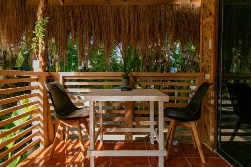 uma mesa e cadeiras numa sala com plantas em Ozen Freediving Hostel em General Luna