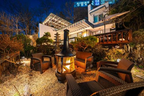 eine Feuerstelle in einem Hof mit Stühlen und einem Haus in der Unterkunft Bs Urban Retreat Garden And Spa Near Gyeongbokgung in Seoul