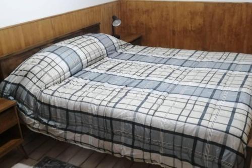 een slaapkamer met een bed met een blauwe en witte deken bij Hermosa casa - Cajon del Maipo in El Canelo