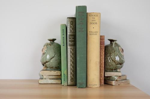 a row of books on a shelf with two vases at Legana Lodge - A home away from home - Catering for up to 12 guests in Legana