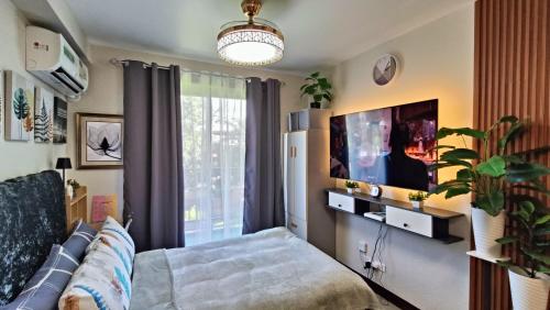 a living room with a couch and a flat screen tv at SAEKYUNG CoNDo HoMESTaY in Lapu Lapu City