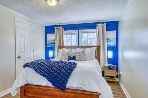 a blue bedroom with a large bed with blue walls at Blue Ridge Haven: Close to Everything! in Asheville