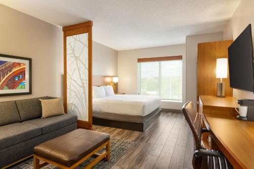 a hotel room with a bed and a couch at Hyatt Place Columbia/Downtown/The Vista in Columbia