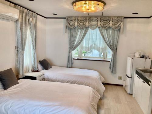 2 camas en una habitación pequeña con ventana en sunset hills - Vacation STAY 21373v, en Hamada