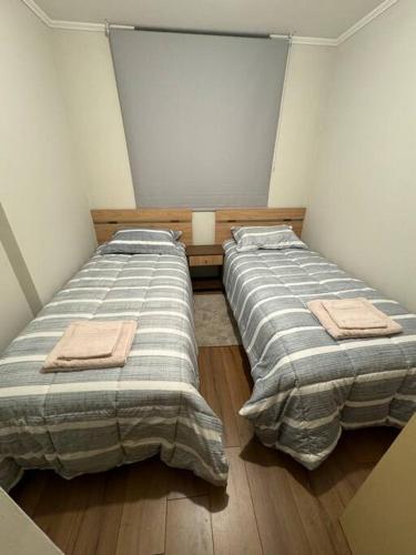 two beds in a small room at Lindo Departamento y muy acogedor in Curicó
