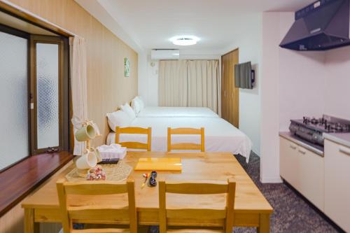 a room with a table and a bed and a kitchen at Tutulu201 in Osaka