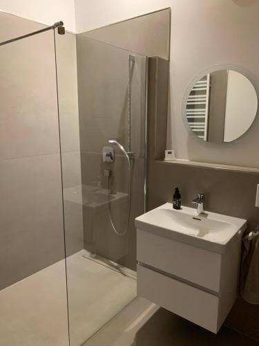 a bathroom with a shower and a sink and a mirror at Modernes Apartment am Waldrand in Geisenheim