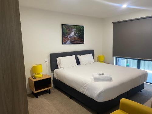 ein Schlafzimmer mit einem großen Bett und einem Fenster in der Unterkunft Luxe & Superior 2BR Villas Patio Free Parking & Wifi in Launceston
