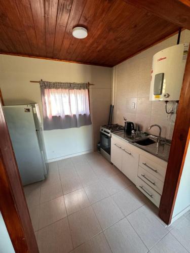 una pequeña cocina con nevera y fregadero en Cabaña cata en Villa Santa Cruz del Lago