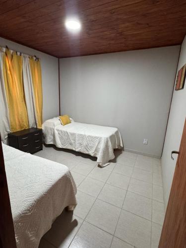 1 dormitorio con 2 camas y techo en Cabaña cata en Villa Santa Cruz del Lago