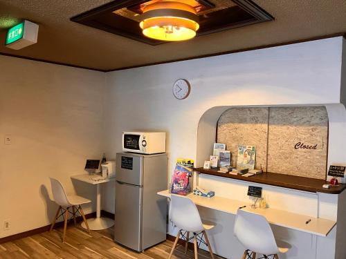 a waiting room with chairs and a counter and a refrigerator at 交流宿　星降る家　いこい in Gujo