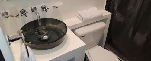 a bathroom with a black bowl sink on a toilet at Glow Boutique Hotel Zona G in Bogotá
