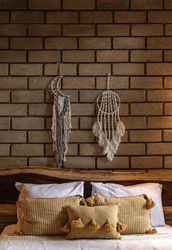 a bedroom with a brick wall and a bed with pillows at Villa Macarena Apartamentos Boutique - Only Adults in Puerto Escondido