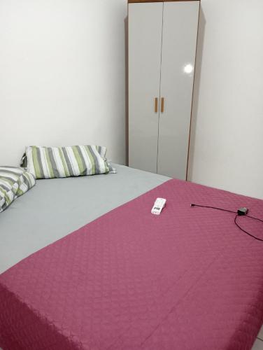 - une chambre avec une couverture rose sur un lit dans l'établissement Aconchego da Barra, à Barra dos Coqueiros