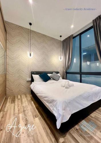 1 dormitorio con 1 cama con sábanas blancas y almohadas azules en Azure@ Gala city Residence 2BR, en Kuching