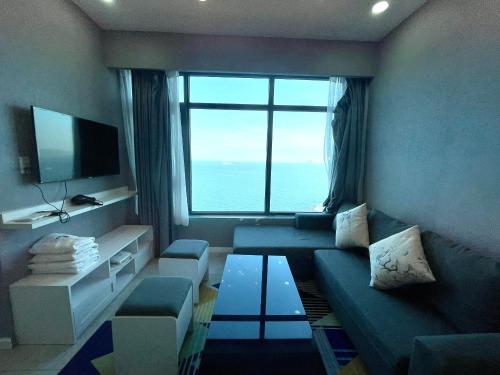 a living room with a couch and a large window at Mường Thanh Oceanus Apartment in Nha Trang