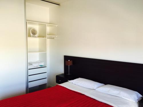 1 dormitorio con 1 cama con manta roja en Apart Hotel Cañuelas en Cañuelas