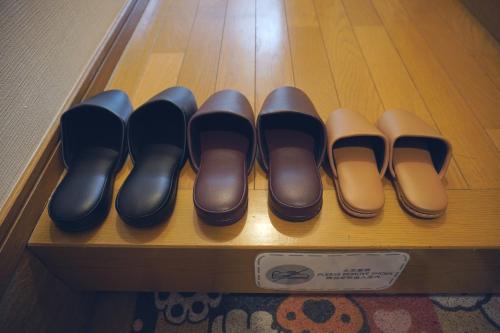 a row of black and brown shoes on a shelf at H2H VILLA鴫野西 三層公寓【JR京橋步行6分鐘】機場直達 容納6人3房1廳 自助入住 帶車位 in Osaka